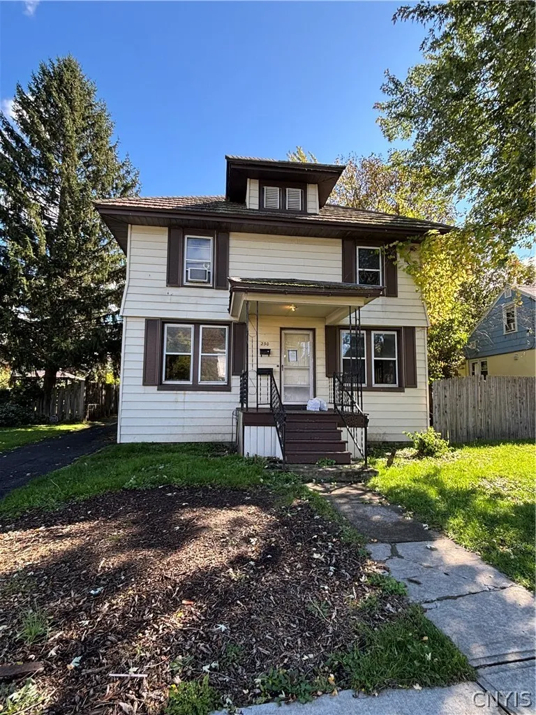 A classic two-story exterior showcases traditional siding and a prominent dormer window under clear skies.