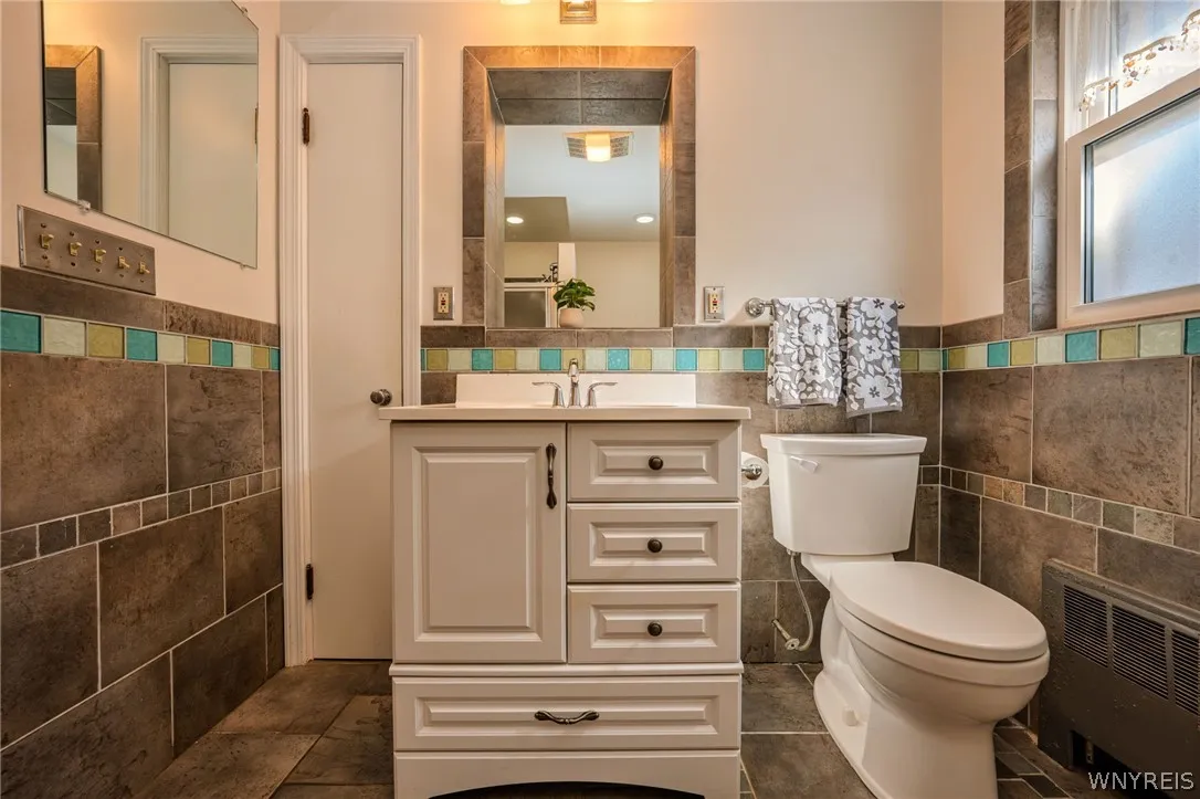 Custom wall tile and a classic single vanity define this functional washroom space.