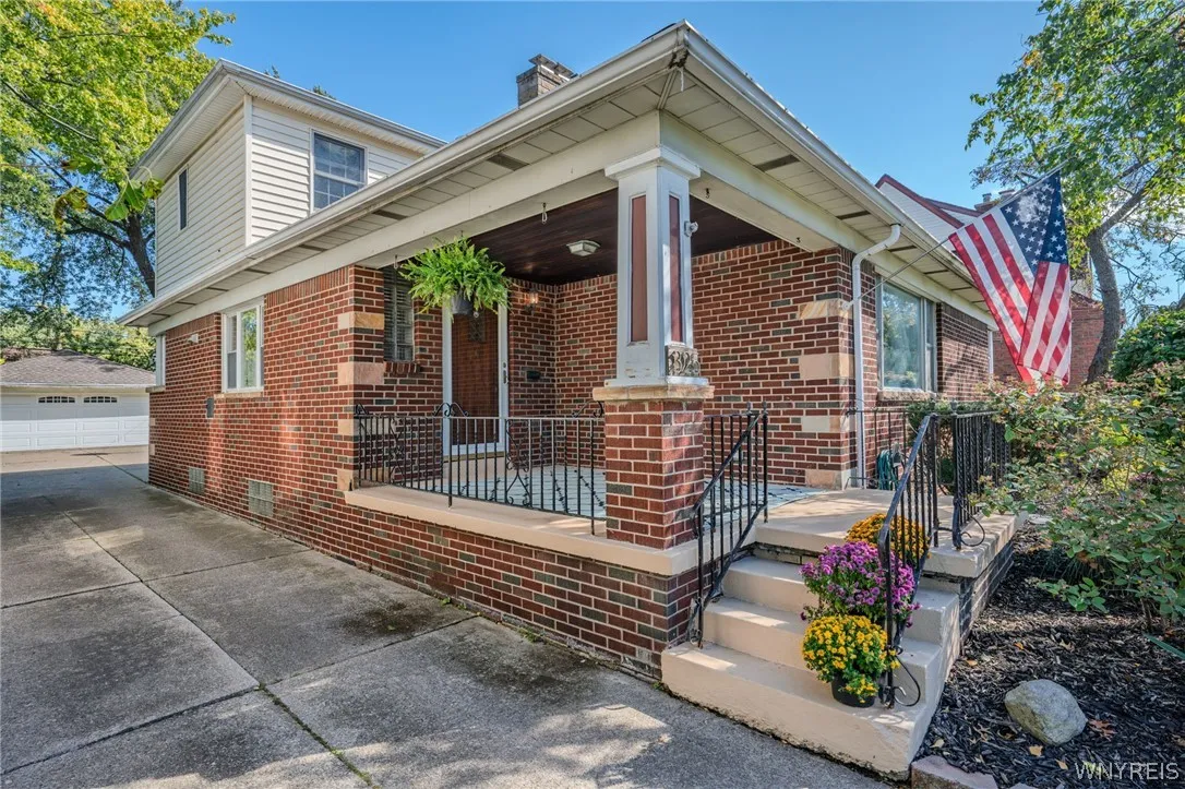 A welcoming front porch with classic brick detailing anchors the exterior of this home.