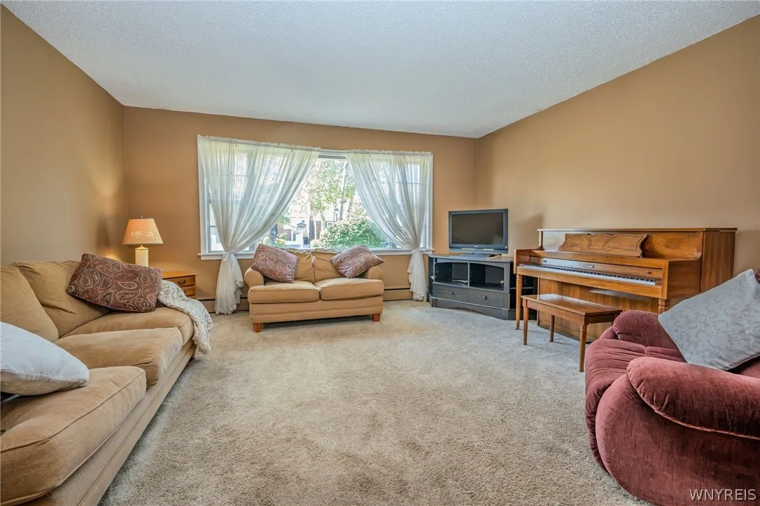 Plentiful natural light streams through a wide window overlooking the neighborhood scenery.
