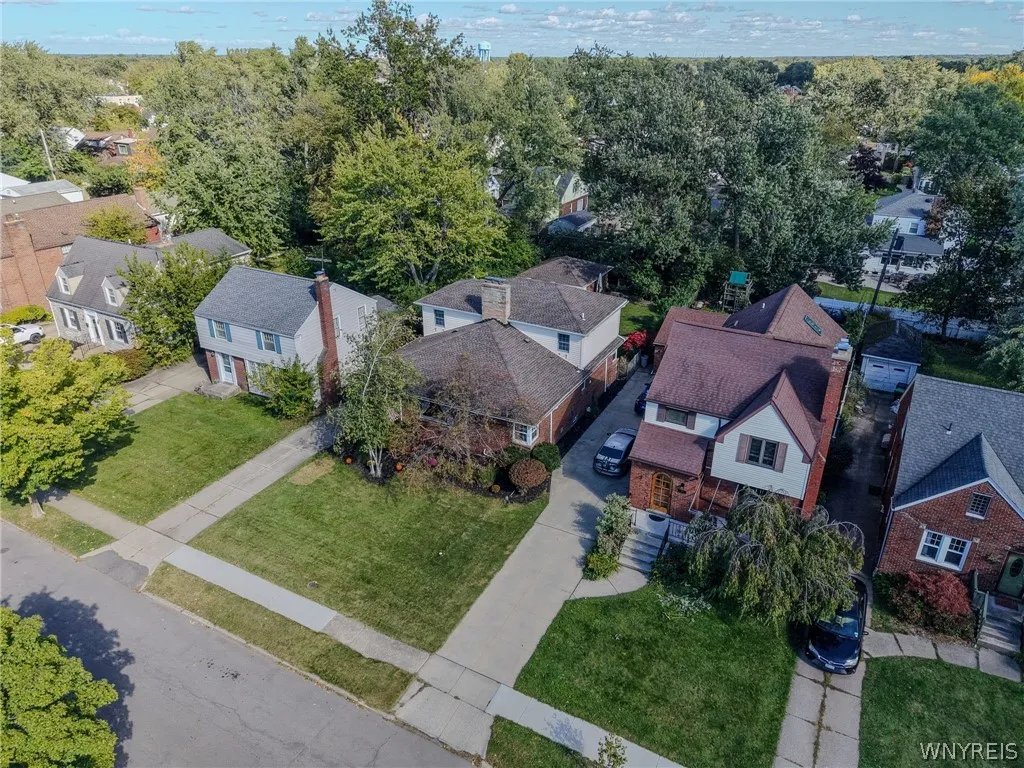 Mature trees frame the neighborhood street and residential properties in this elevated perspective.