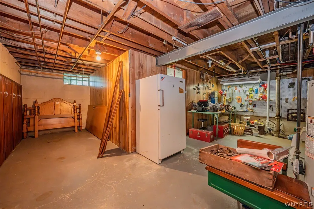 Exposed wood joists and concrete floors define this highly functional unfinished basement workspace.