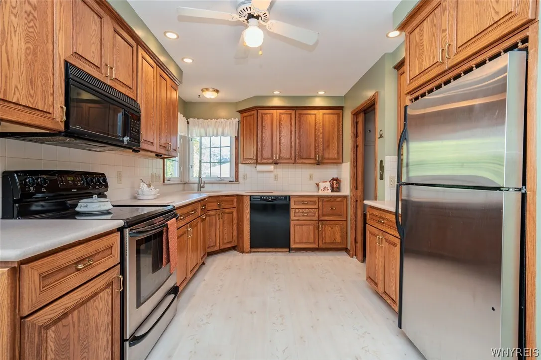 Warm oak cabinetry pairs with light flooring in this spacious, well-appointed kitchen.