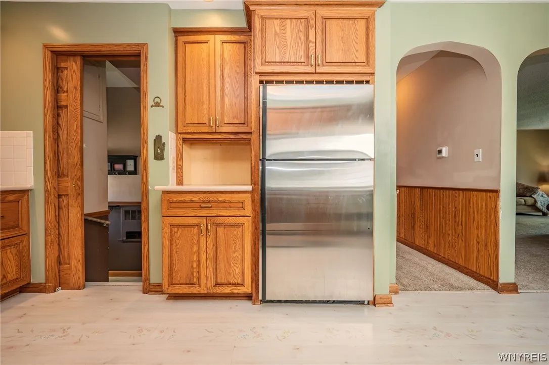 Rich wood trim frames arched entries and custom cabinetry alongside modern stainless steel appliances.