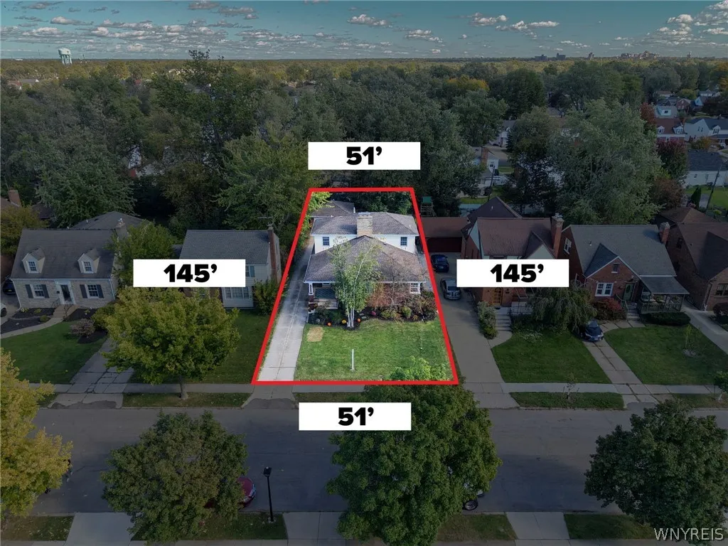 Mature trees frame a deep residential parcel set along a paved neighborhood street.