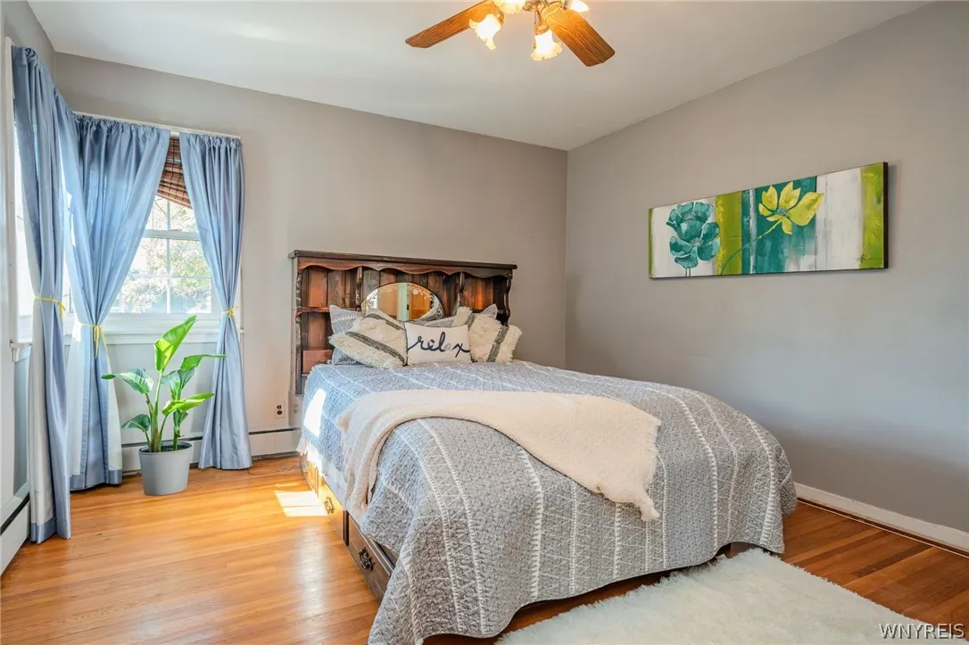 Warm hardwood floors and a classic sash window elevate this comfortable bedroom space.