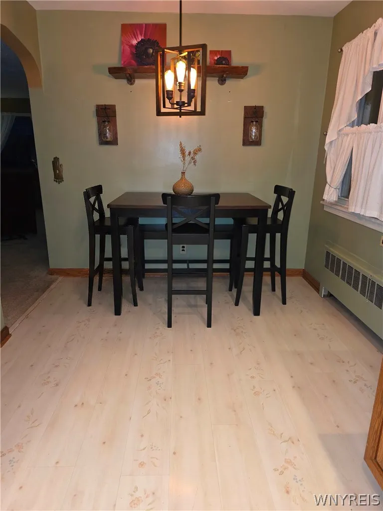 Gleaming light wood flooring pairs beautifully with classic baseboard trim in this inviting dining area.
