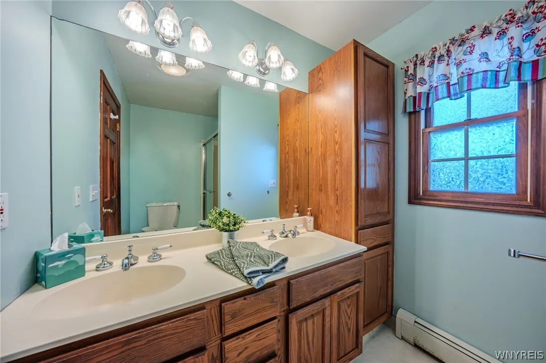 Double vanities and rich wood cabinetry anchor this classic bathroom space.