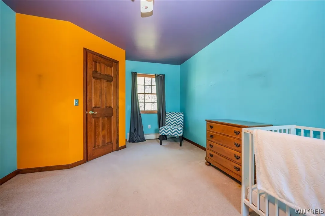 Rich wood trim and soft carpeting define this colorful secondary bedroom space.