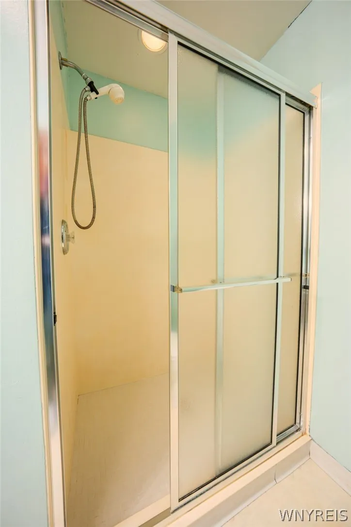 Frosted glass sliding doors enclose this practical walk-in shower.