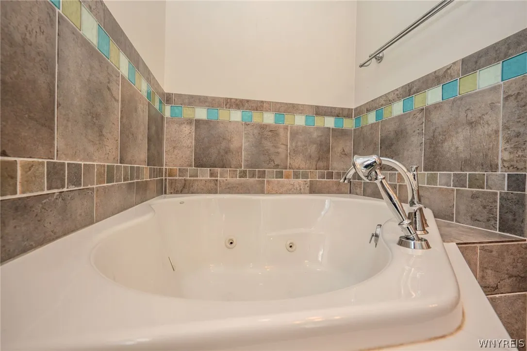 Custom tilework frames a deep soaking tub complete with integrated jets.