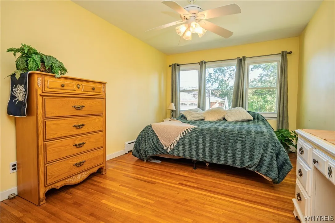 Warm hardwood flooring and ample natural light define this cozy sleeping space.