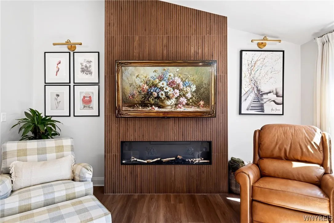 An elegant contemporary fireplace with detailed wood paneling serves as the focal point.