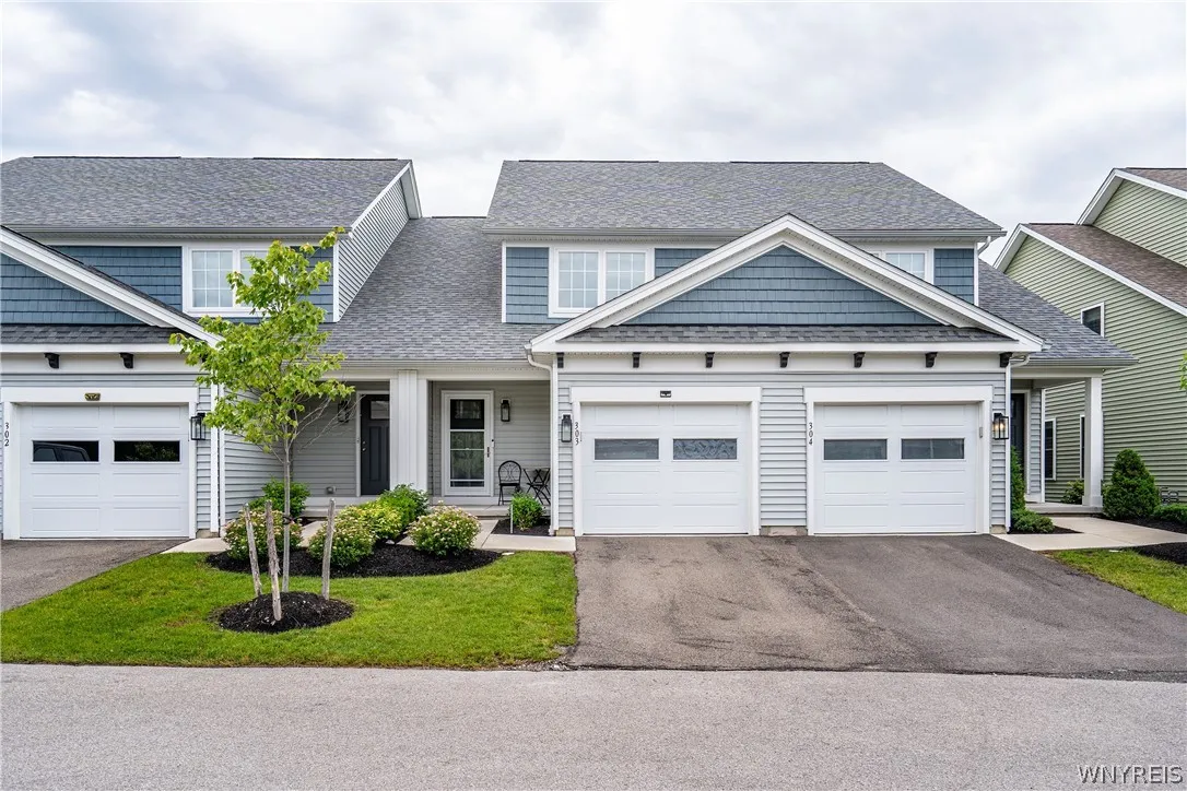 Multi-textured siding and architectural gables define this charming townhouse exterior with attached garages.