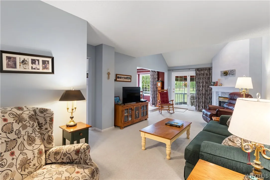 Vaulted ceilings and broad sliding doors maximize natural light across this open living space.