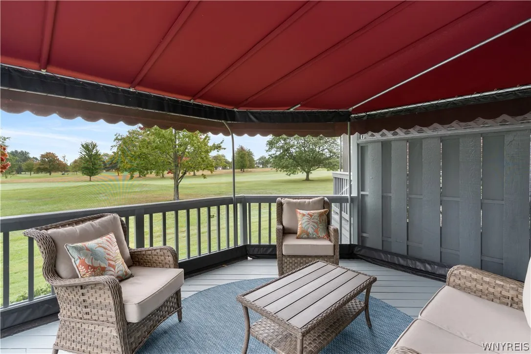 A covered deck looks out onto a serene, manicured golf course fairway.