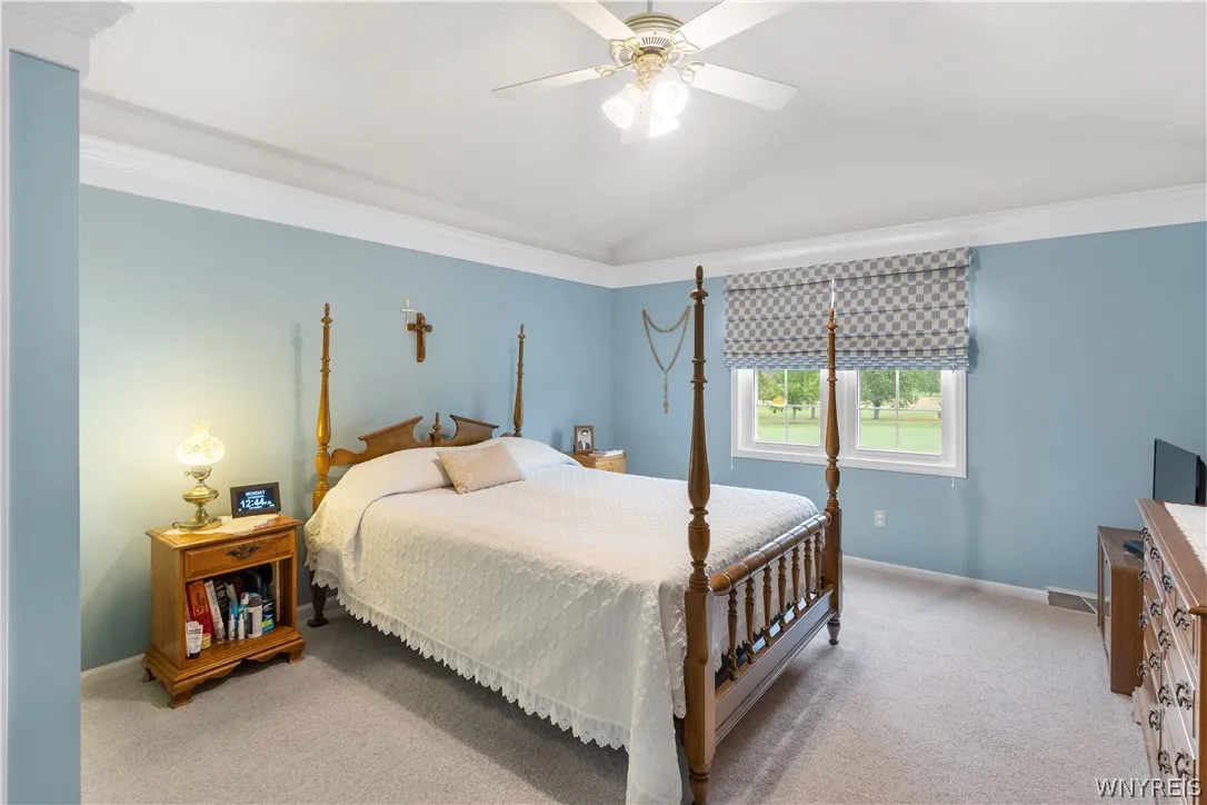 Elegant crown molding and soft carpeting enhance this bedroom with classic architectural details.