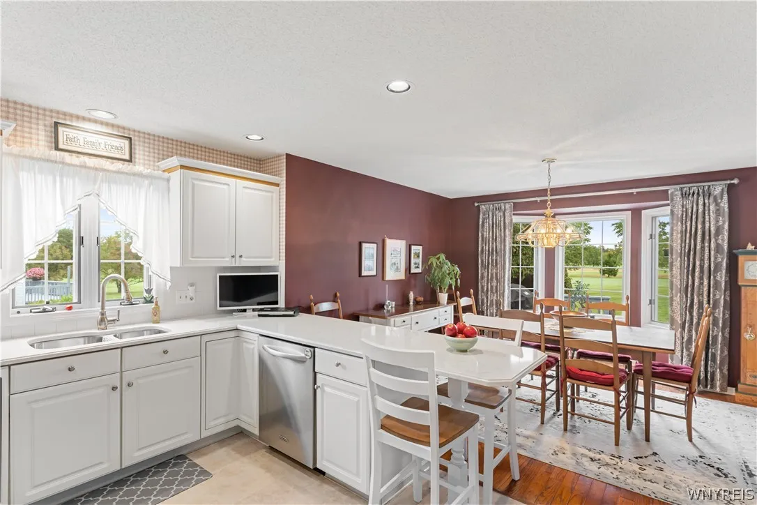 Gleaming stone countertops and classic wood flooring flow seamlessly into an inviting dining area.