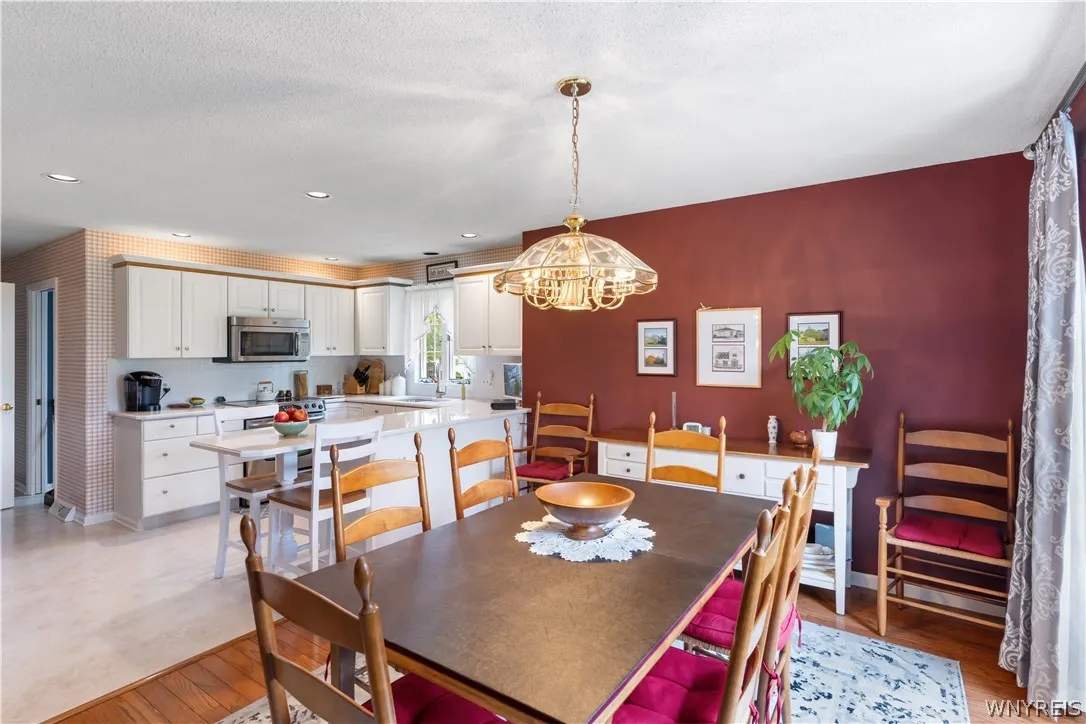 Gleaming hardwood floors and a spacious layout connect the inviting dining area to the kitchen.