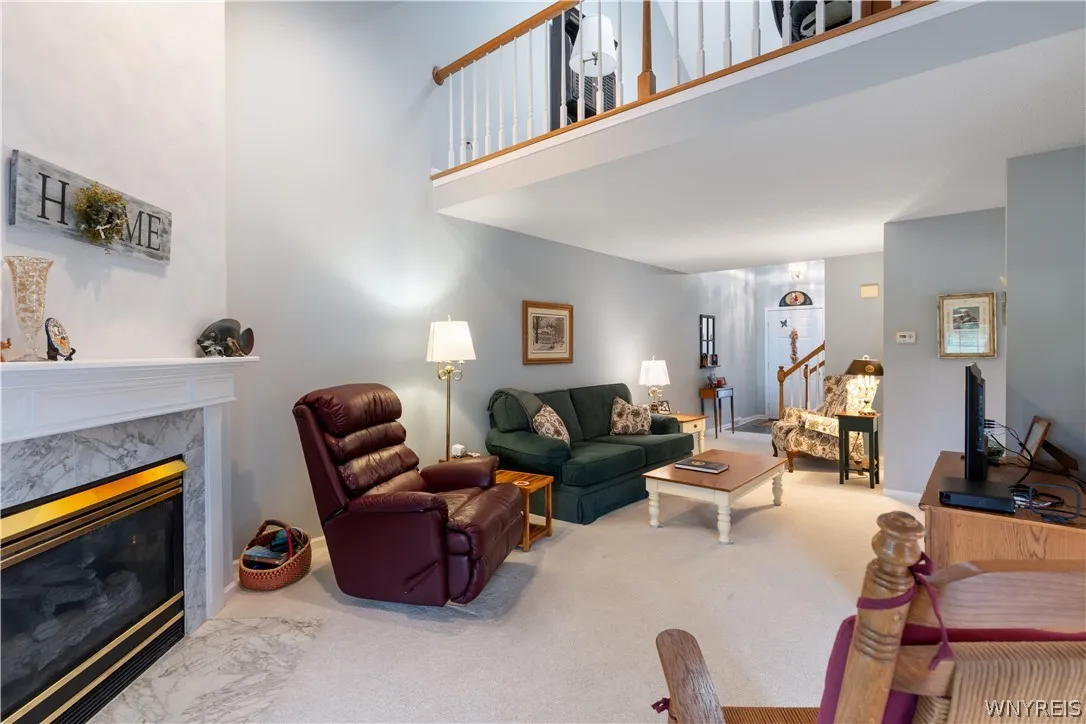 High ceilings and a stone-faced fireplace anchor this airy, light-filled living area.