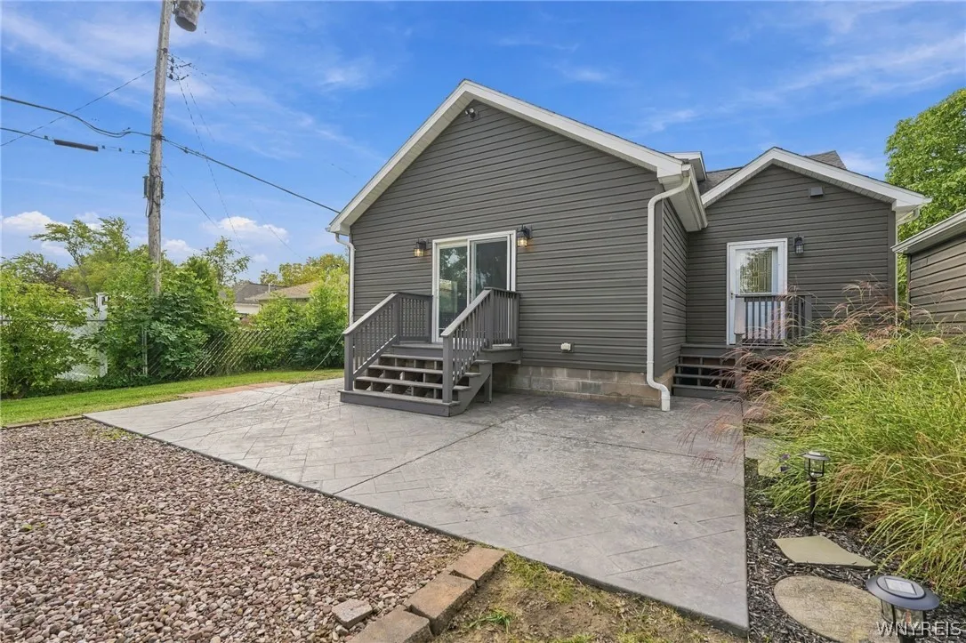 A spacious concrete patio stretches out from the back of this vinyl-sided home.