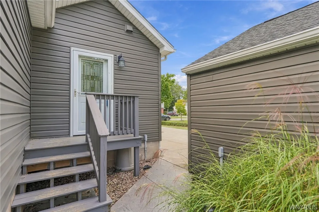 A private side entry features elevated wooden steps, classic siding, and a decorative glass door.