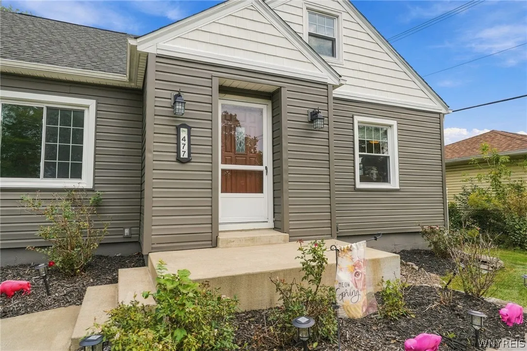 Concrete steps lead to a welcoming front entrance framed by classic siding.