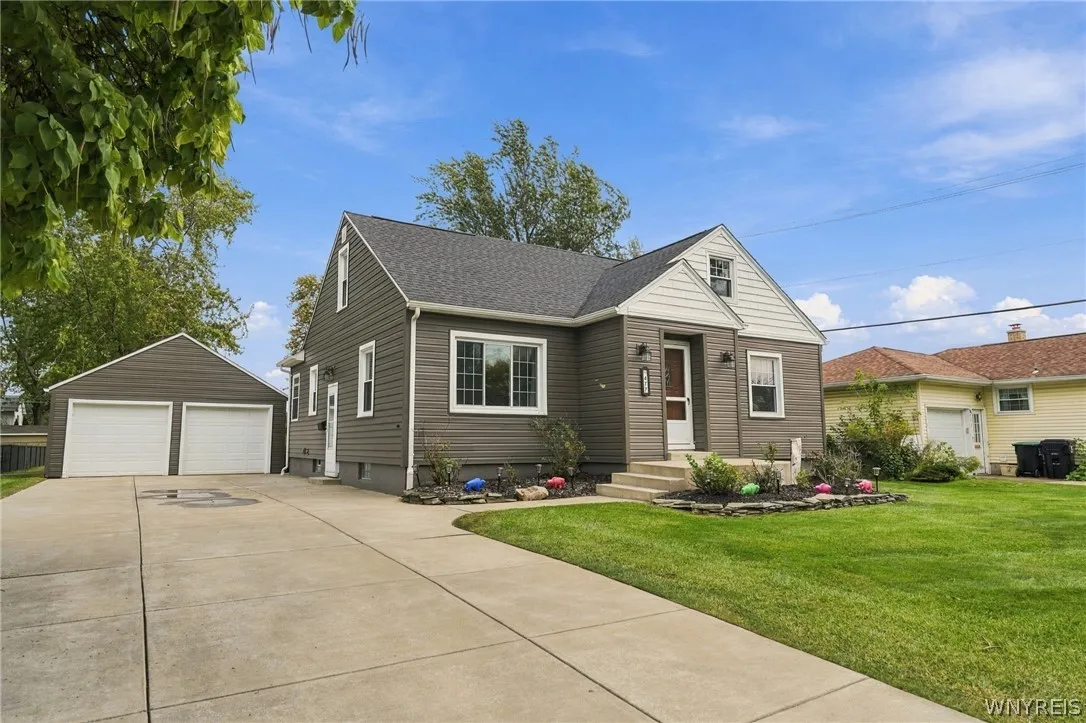 A concrete driveway leads to this charming home with a detached two-car garage.