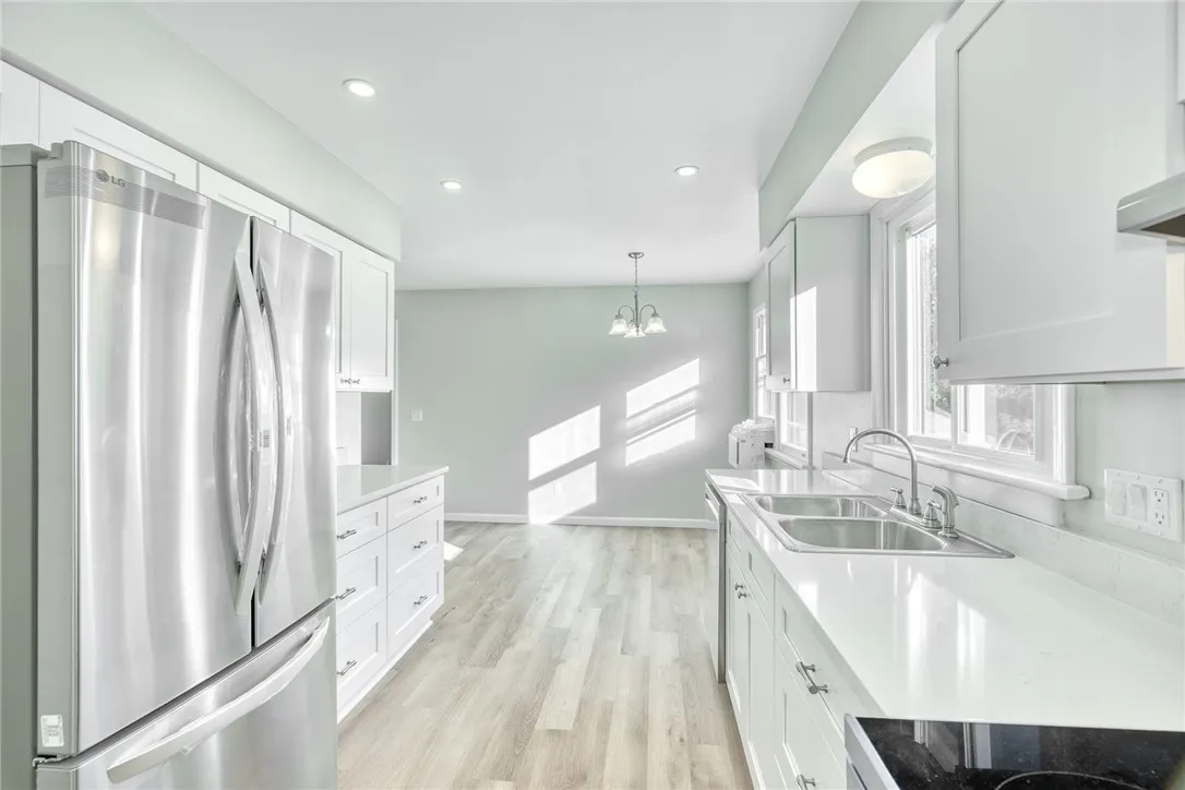 UPDATED KITCHEN! White cabinetry, gorgeous quartz countertops, stainless steel appliances, recessed lighting & additional cabinetry for extra storage and workspace!