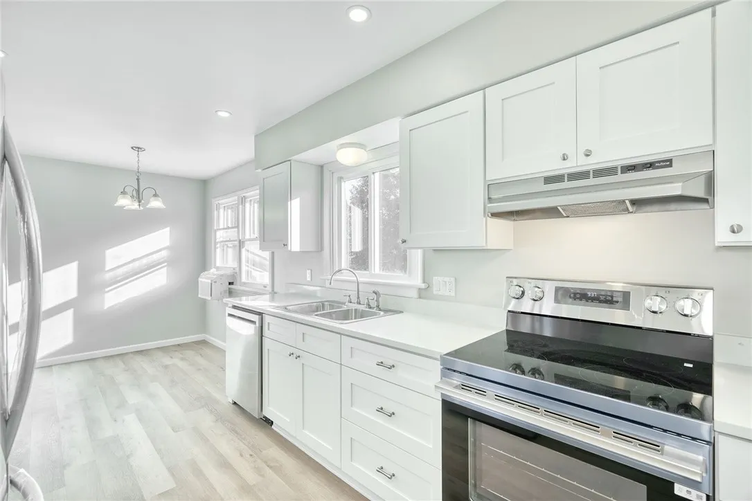 UPDATED KITCHEN! White cabinetry, gorgeous quartz countertops, stainless steel appliances, recessed lighting & additional cabinetry for extra storage and workspace!