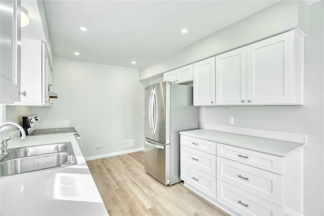 UPDATED KITCHEN! White cabinetry, gorgeous quartz countertops, stainless steel appliances, recessed lighting & additional cabinetry for extra storage and workspace!