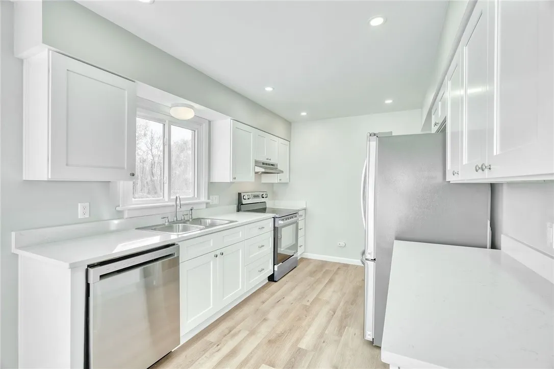 UPDATED KITCHEN! White cabinetry, gorgeous quartz countertops, stainless steel appliances, recessed lighting & additional cabinetry for extra storage and workspace!