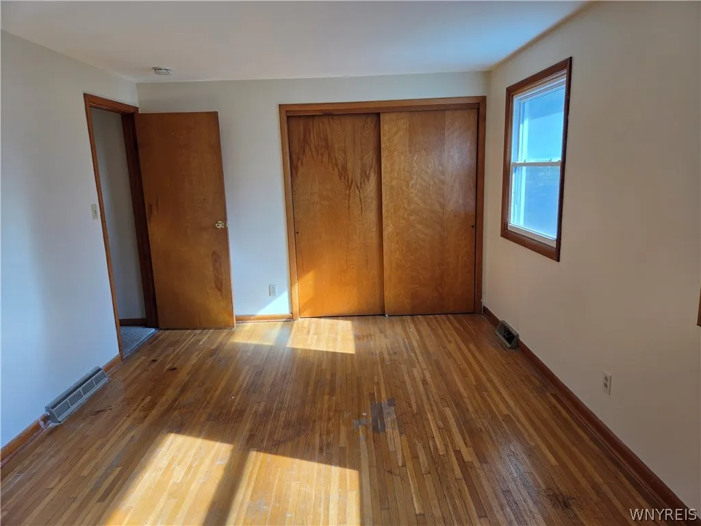Large bright primary bedroom with a huge closet original exposed hardwood floor