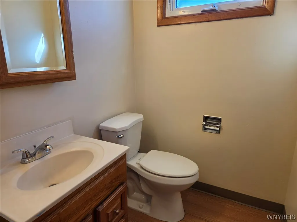 Half bath with new flooring& fixtures features a medicine cabinet and vanity for storage