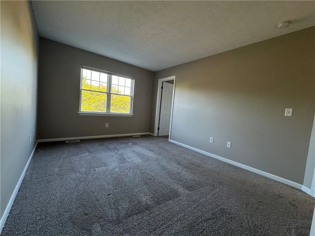 Typical primary bedroom with carpeting and large walk-in closet