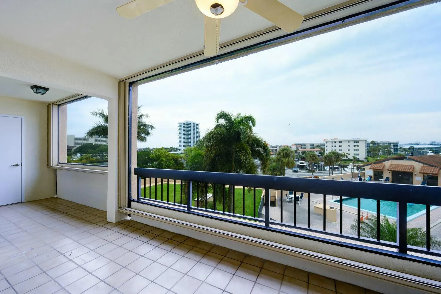 Screen enclosed balcony with accordion shutters.