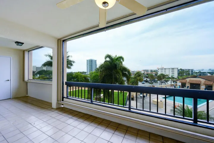 Screen enclosed balcony with accordion shutters.