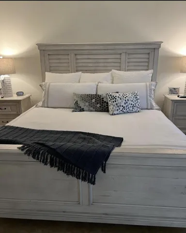 Soothing sounds of the beach lapping at the shore, the king size bed is weathered off-white wood compliment this beach home.