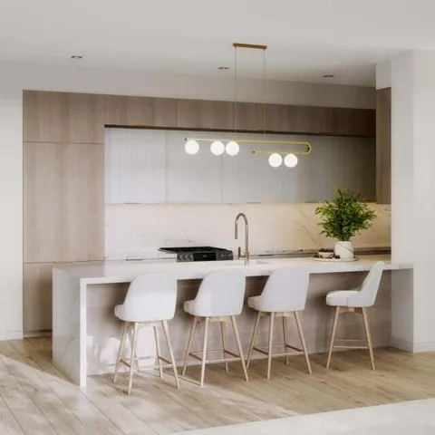 DEFINING OPPULENCE WITH BEAUTIFUL FLAT PANNELED CABINETRY, ELONGATED DINING ISLAND WITH 3 INCH CALCUTTA WATERFALL FINISH & BACKSPLASH, CUSTOM LIGHTING AND BRUSHED BRONZE HARDWARE & FIXTURES