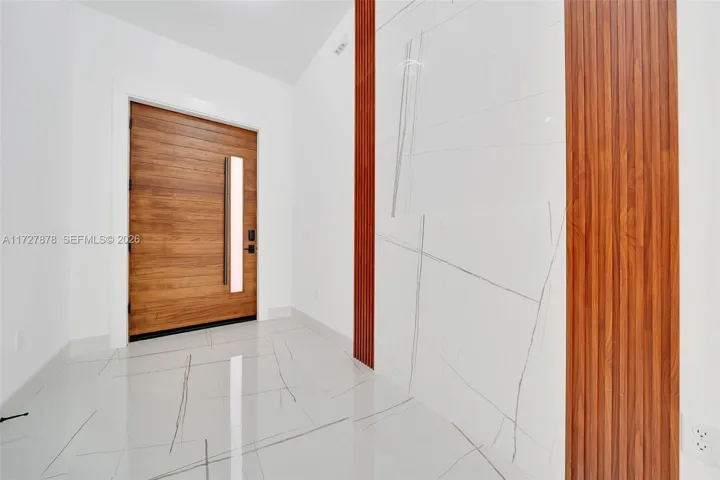 FOYER WITH WATERFALL OF TILE TRIMMED WITH MAHOGANY ACOUSTIC PANELS