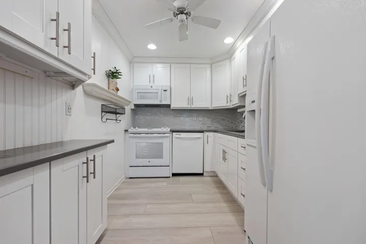 White shaker style cabinets w/ glass tile backsplash & quartz countertops