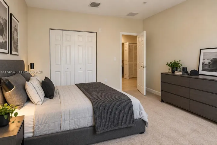 Neutral-toned interior space featuring wall-to-wall carpeting, a multi-panel sliding closet, and a standard interior swinging door