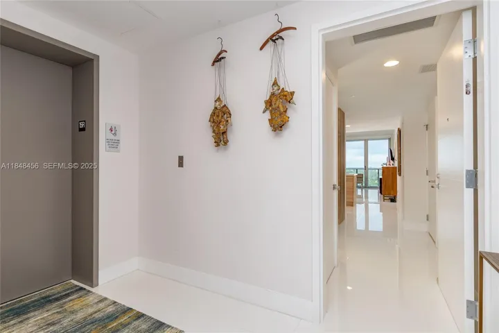 Elevator opens to Private Foyer. Door entrance to the condo. White porcelain floors throughout
