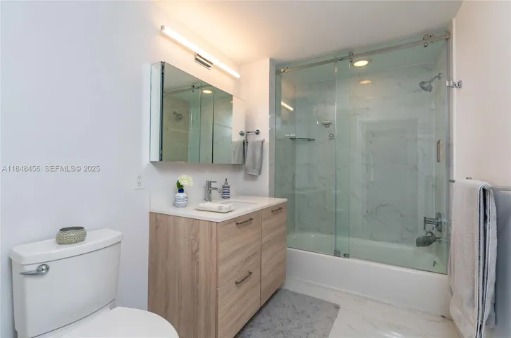 2nd Bathroom - double doors: 1 opens to the bedroom & 1 door opens to the corridor for guests. Bathtub with glass door, designer lamp, mirror cabinets for extra storage, and the left side of the cabinet was converted into 2 drawers, more convenience than just a shelf.