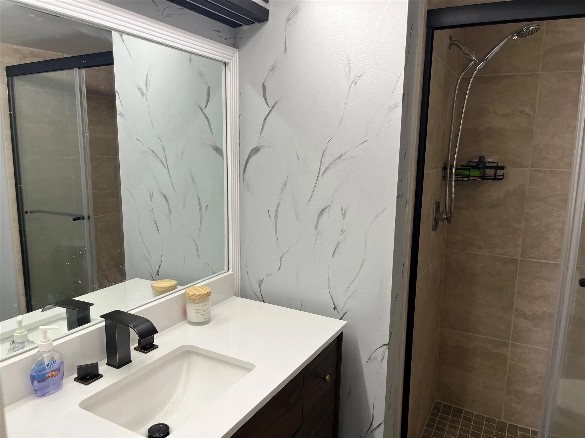 Updated master bathroom with shower. New tiles, floors, sink and vanity. Design light fixtures.