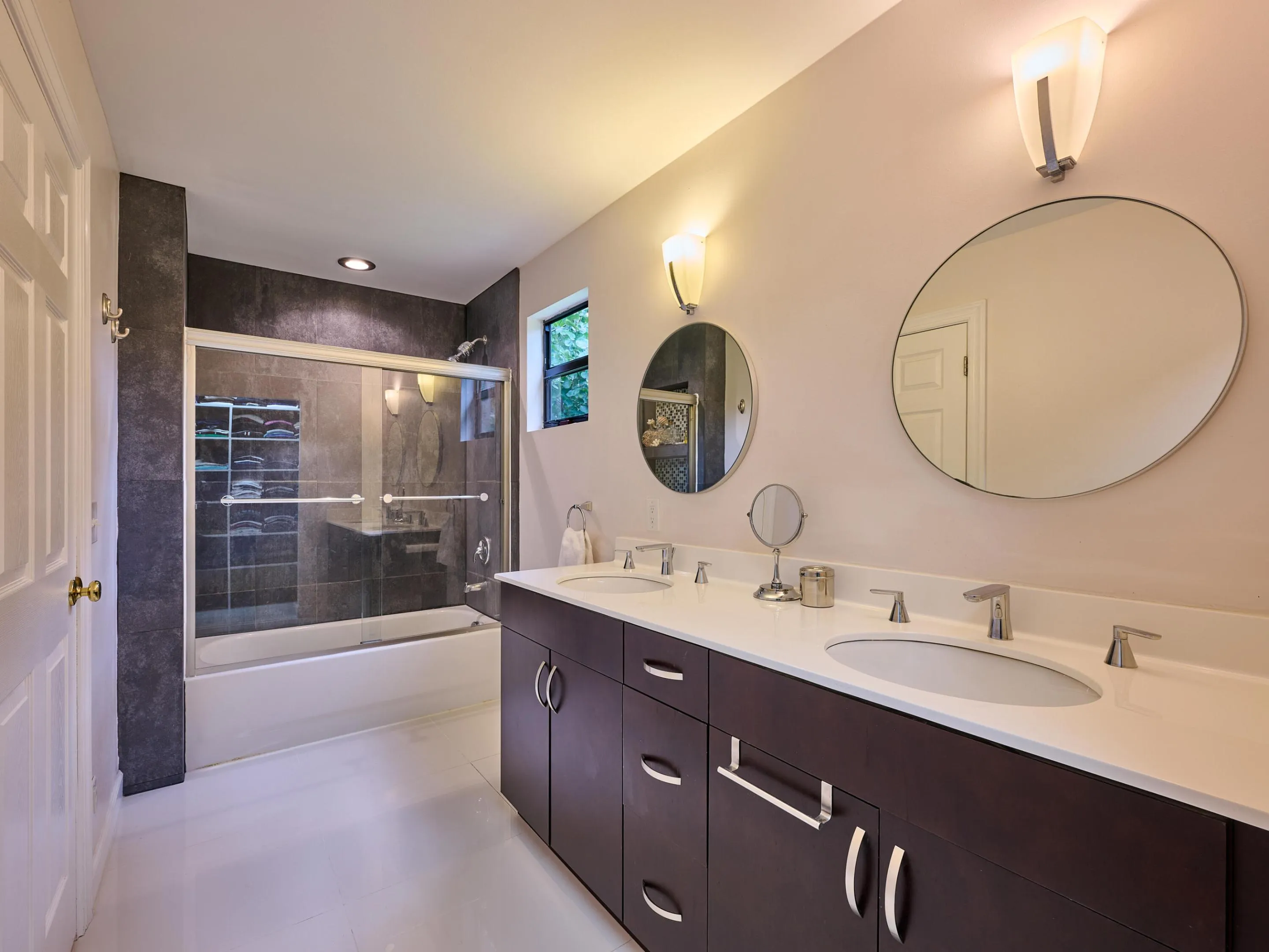 Dual Sinks and glass enclosed tub with shower in Primary.