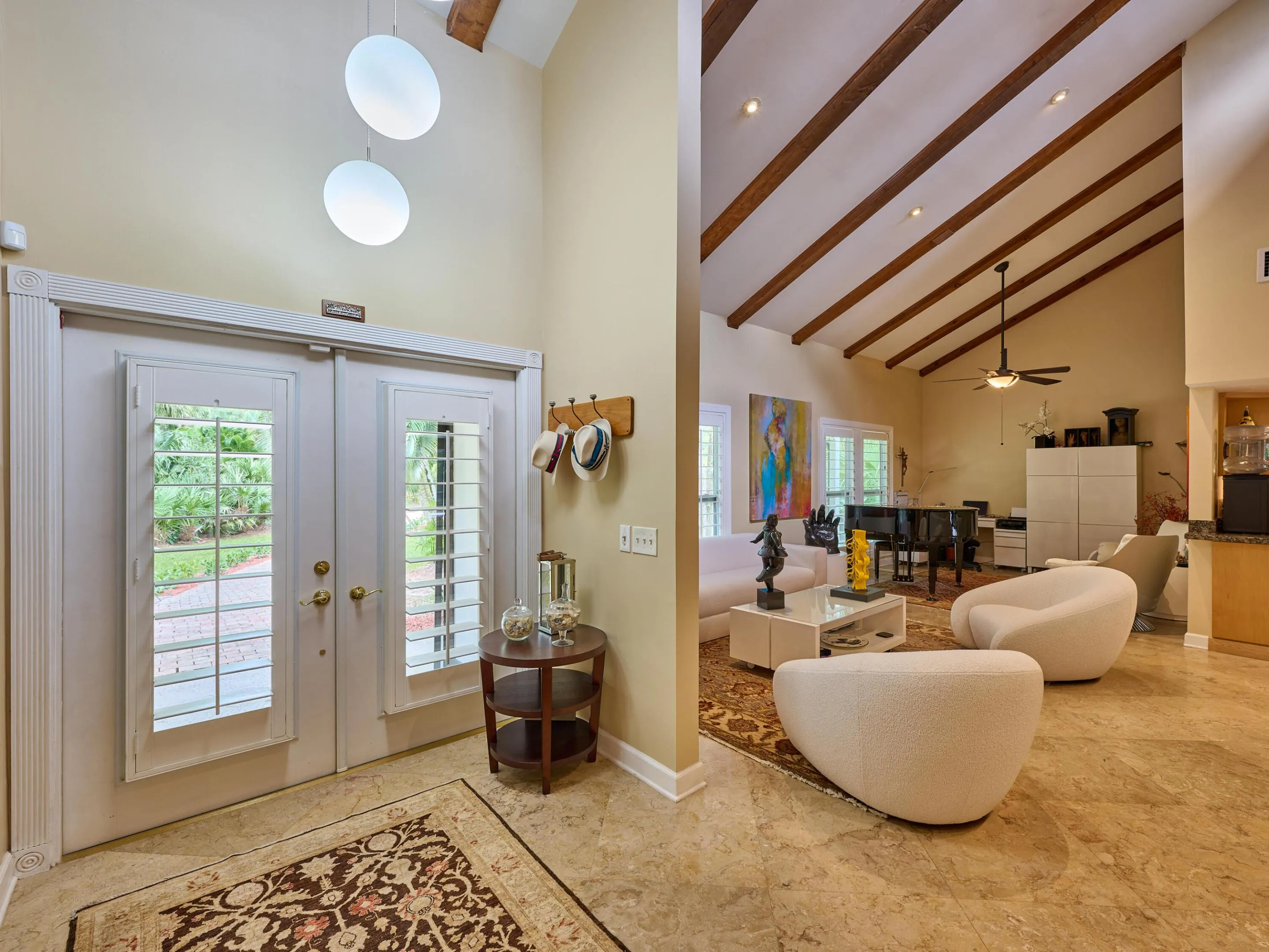 Home beckons with French Doors from covered entry past the plantation shutters and into your open concept living space.