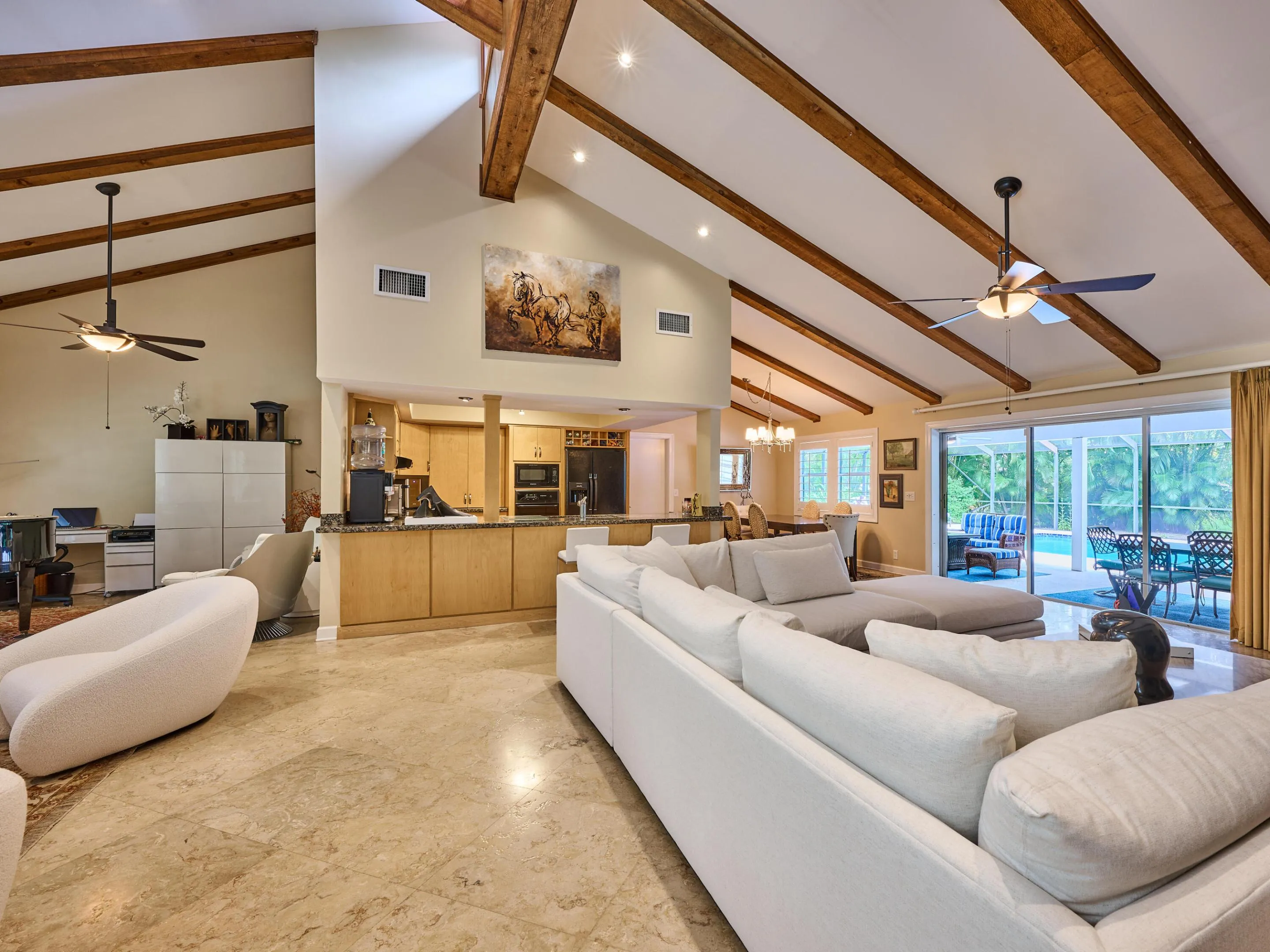 The family room opens to the kitchen, formal dining and Doors out to the stunning screen enclosed pool.