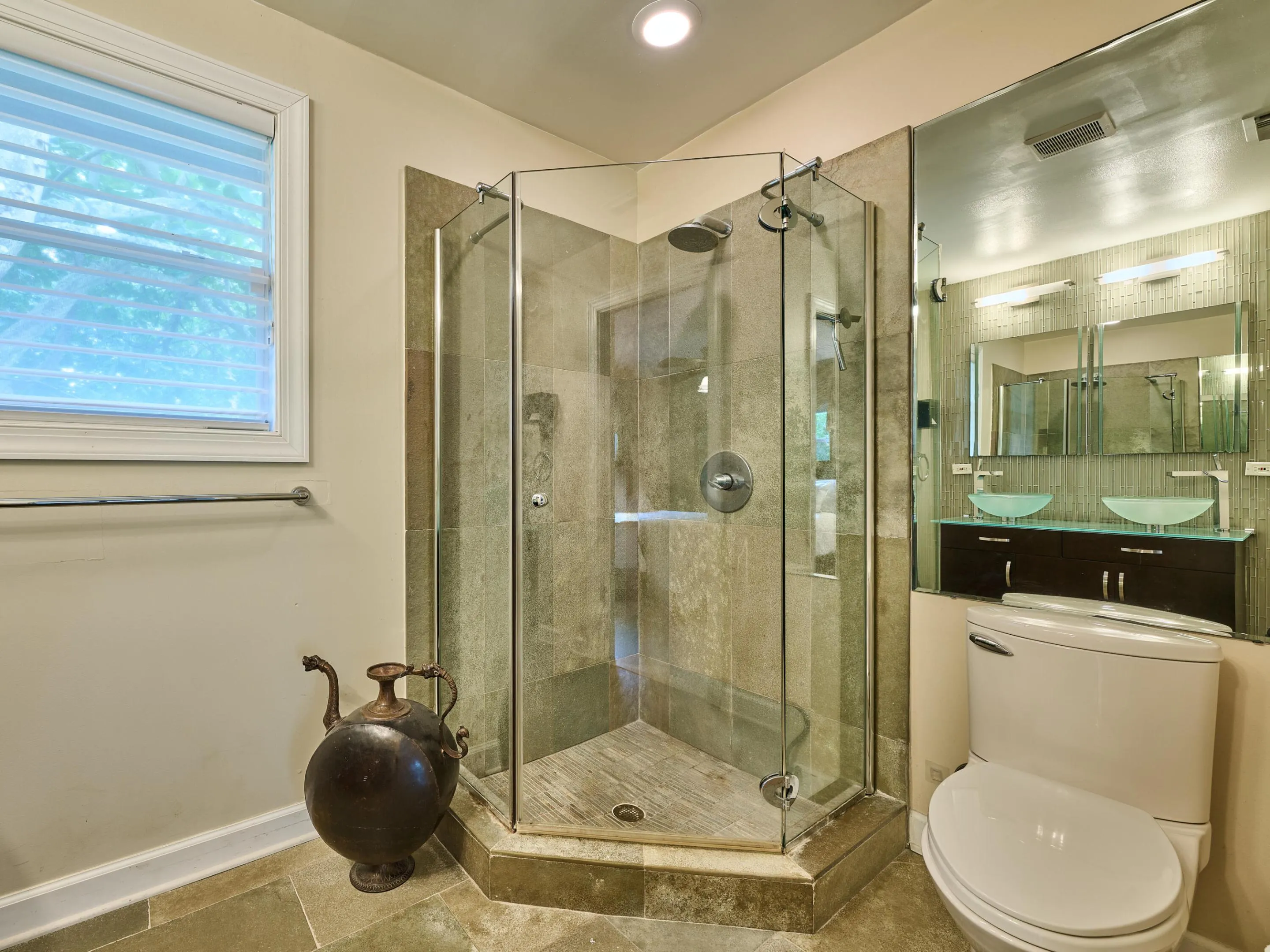 Glass enclosed shower and spacious room.