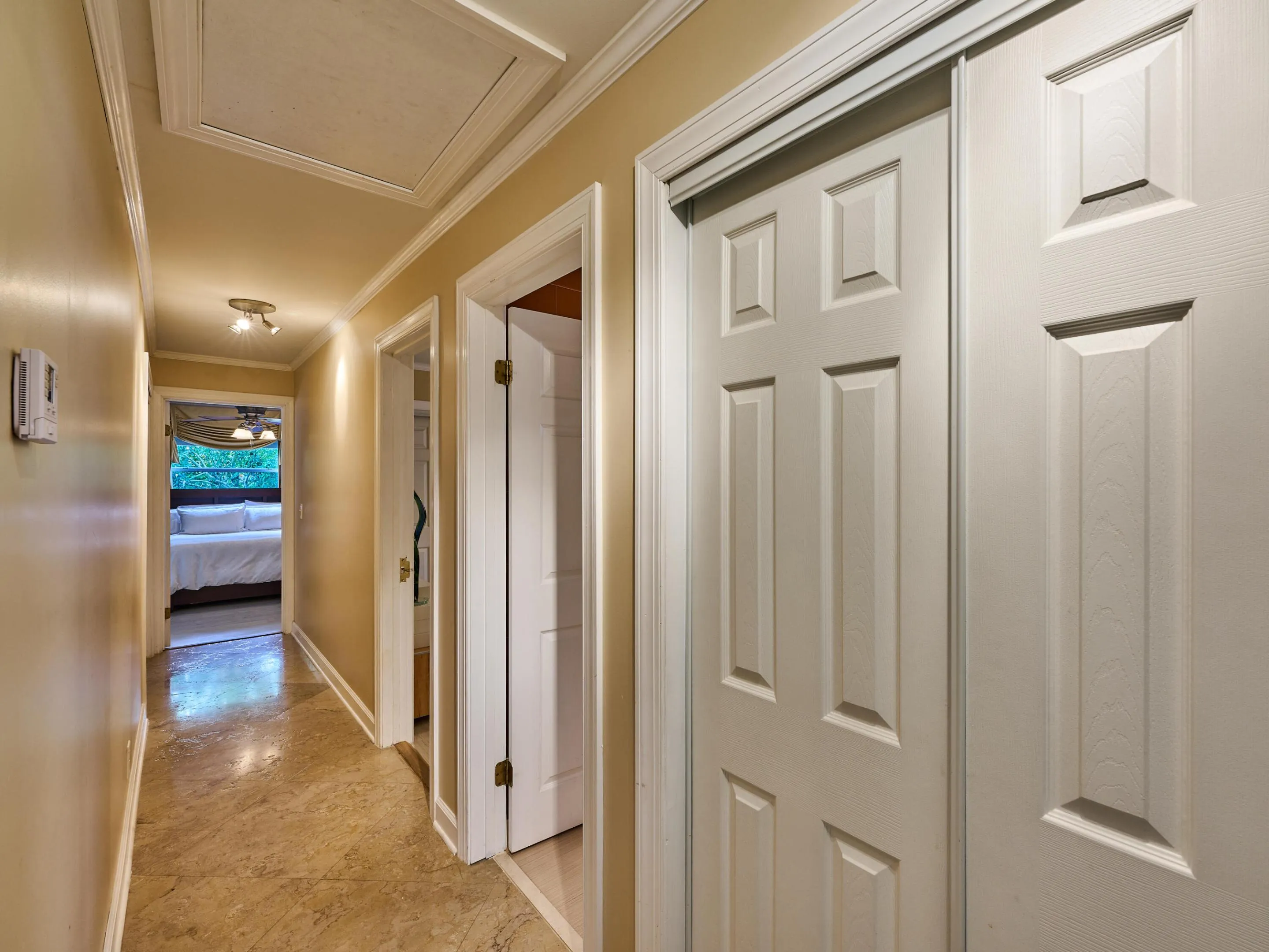Turning to the right from the foyer, enter the bedroom wing where you'll find 3 bedrooms and 2 ensuite baths and 1 community bath. Notice the beautiful tile continues without a break in continuity.